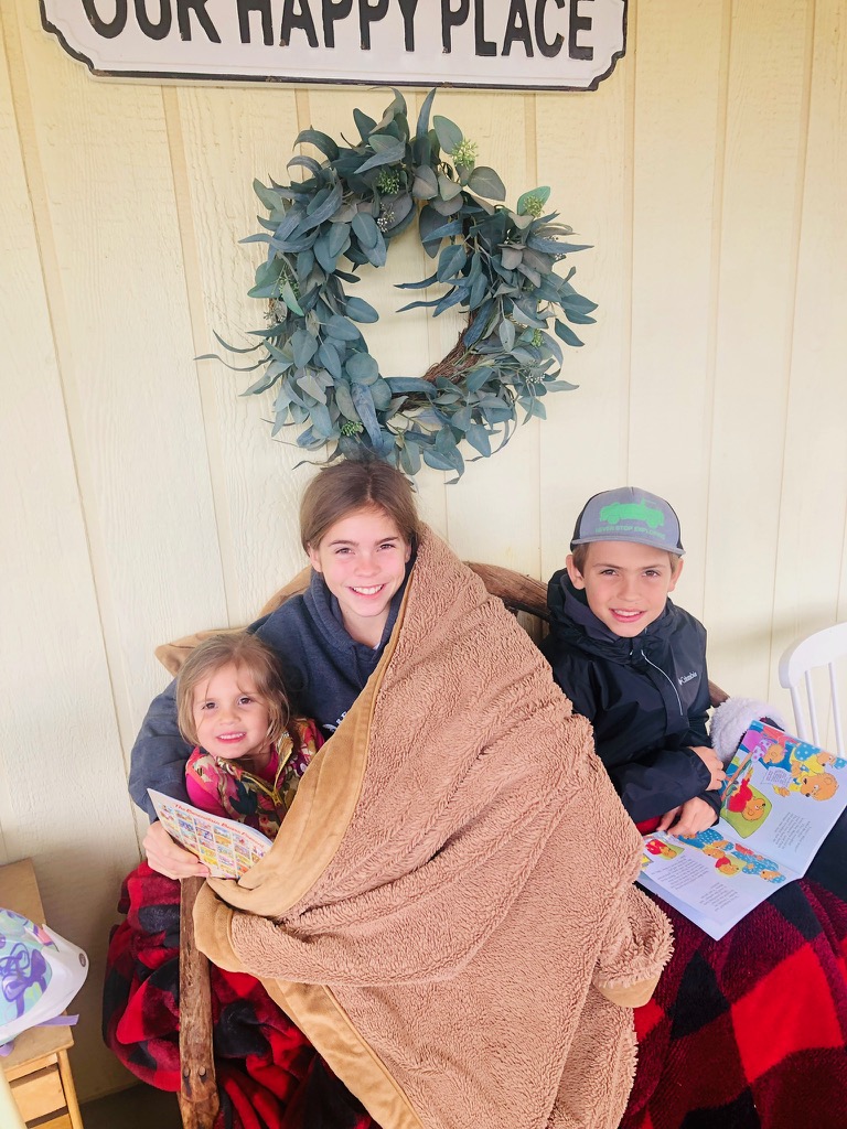 Reading with siblings on the porch for family quarantine routine